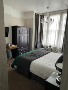 Un dormitorio con una cama grande y una lámpara de araña. en Most Easterly en Pakefield