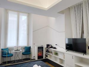 a living room with a television and two blue chairs at CASA IVH BNB in Florence