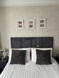 a bed with a black headboard and two pillows at Most Easterly in Pakefield