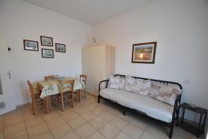 a room with a bed and a table and a table and chairs at Bilocale Lavanda - 100 mt. dal mare con clima in Marina di Campo