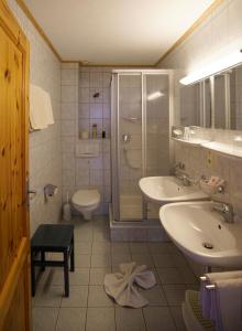 een badkamer met een douche, een wastafel en een toilet bij Pano6 in Lermoos