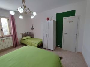 een slaapkamer met 2 bedden en een groene muur bij Casetta GGG in SantʼEufemia Lamezia