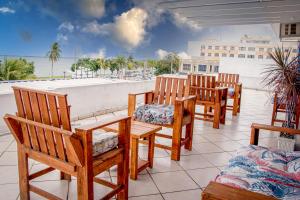 a group of wooden chairs and tables on a balcony at Orla de Araruama in Araruama