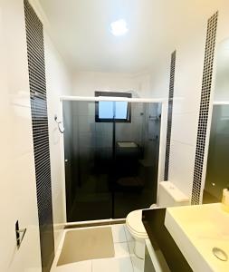 uma casa de banho com um chuveiro e um WC. em Espaçoso & Aconchegante AP - Até 10 pessoas. em Santa Cruz do Sul