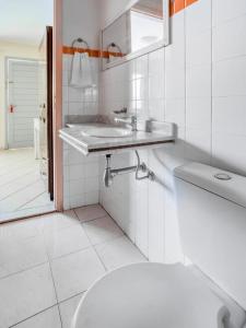 a white bathroom with a sink and a toilet at Orla de Araruama in Araruama