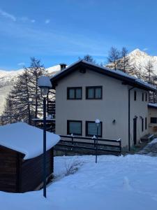 a white house with snow on the ground at Green Mountain Lodge in Sauze dʼOulx