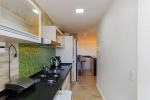 uma cozinha com um lavatório e um fogão em Apartamento Espaçoso & Aconchegante - 3 quartos em Porto Alegre