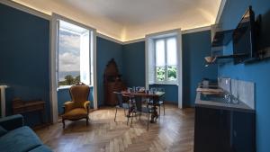 a living room with blue walls and a table and chairs at Venegoni Maison De Charme in Ghiffa