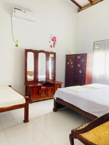 a bedroom with two beds and a mirror at SAKURA Guest House Tourist only in Wariyapola