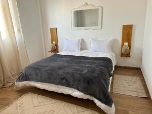 - une chambre avec un grand lit et une couverture noire dans l'établissement Villa la crête, à Béjaïa