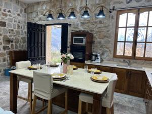 une cuisine avec une grande table, des chaises et un comptoir dans l'établissement Villa la crête, à Béjaïa