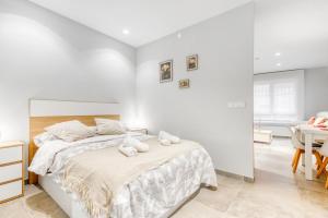 ein weißes Schlafzimmer mit einem Bett mit Handtüchern darauf in der Unterkunft Lovely & Modern flat in Heart of Castellón in Castellón de la Plana