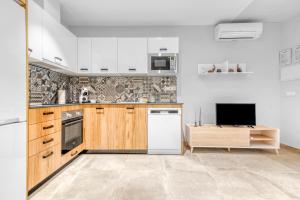 cocina con armarios de madera y nevera blanca en Lovely & Modern flat in Heart of Castellón, en Castellón de la Plana