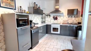 a kitchen with stainless steel appliances and tile floors at Galets Blancs Yourhosthelper in Royan