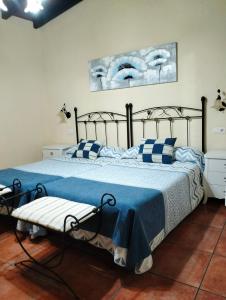 a bedroom with a bed with blue and white pillows at Casa Rural Josefina 1 y 2 in Navaconcejo