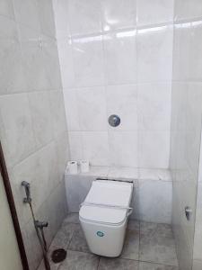 y baño blanco con aseo y ducha. en Hotel Vallabh Vilas en Hoshangābād