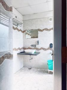 a bathroom with a sink and a toilet at Hotel Vallabh Vilas in Hoshangābād