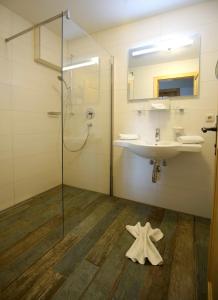 een badkamer met een wastafel en een glazen douche bij Zugspitze 6,7 in Lermoos