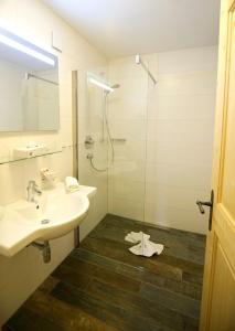 een badkamer met een wastafel en een glazen douche bij Zugspitze 6,7 in Lermoos