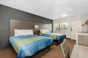 Habitación de hotel con 2 camas y ventana en Grove City Travel Inn, en Grove City