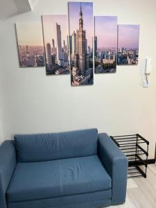 - un canapé bleu dans une chambre avec une ville dans l'établissement Wola Studio Flat near Progresia, à Varsovie