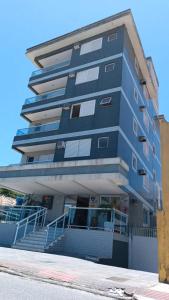 佛羅安那波里的住宿－Hotel Lacala，一座高大的蓝色建筑,前面有楼梯