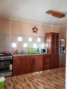 a kitchen with wooden cabinets and a stove and refrigerator at Casa Piedra Blanca in Cachí