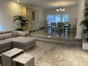 Una sala de estar con un sofá y un comedor. en Vakantiewoning Villa 35, en Maasmechelen