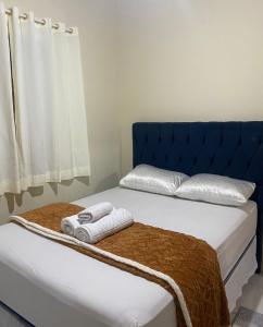 a blue bed with two towels on top of it at Casa Aconchego in Mucugê
