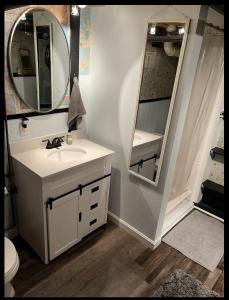 W łazience znajduje się umywalka i lustro. w obiekcie Guest Space on the Portland Peninsula w mieście Portland