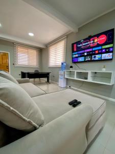 Alojamiento RBOY Las Mariposas في شيلان: غرفة معيشة مع أريكة وتلفزيون بشاشة مسطحة