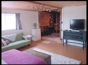 Guest Space on the Portland Peninsula في بورتلاند: غرفة معيشة مع أريكة وتلفزيون بشاشة مسطحة