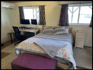 Guest Space on the Portland Peninsula في بورتلاند: غرفة نوم مع سرير ومكتب مع جهاز كمبيوتر