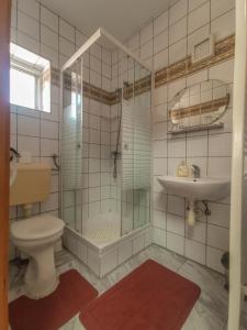 a bathroom with a shower and a toilet and a sink at Hévíz Kristály Apartman in Hévíz