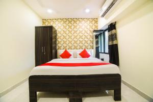 a bedroom with a large bed with red pillows at OYO Hotel Sonali in Nagpur