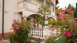 ヘーヴィーズにあるHévíz Kristály Apartmanの白塀とピンクの花の家