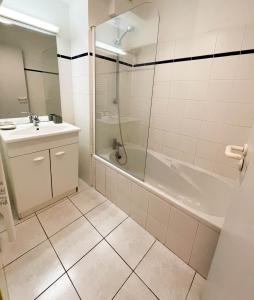 La salle de bains est pourvue d'une douche, d'un lavabo et d'une baignoire. dans l'établissement Bel appartement sur les hauts de Collioure, à Collioure