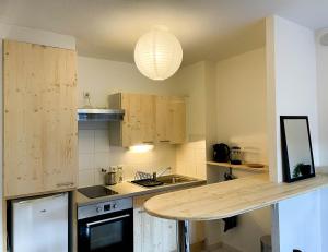 - une cuisine avec des placards en bois et une table dans l'établissement Bel appartement sur les hauts de Collioure, à Collioure