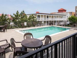 大洋城的住宿－Ocean City Beach Retreat with Linens Included，一个带桌椅的庭院和一个游泳池