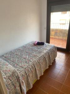 Bett mit einer Decke auf dem Zimmer in der Unterkunft Apartamento frente al Mediterraneo in Torreblanca