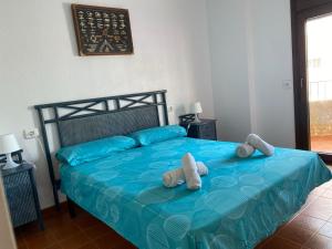 ein Schlafzimmer mit einem blauen Bett mit ausgestopften Tieren darauf in der Unterkunft Apartamento frente al Mediterraneo in Torreblanca