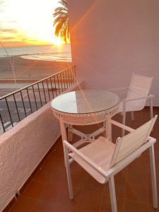 einen Tisch und einen Stuhl auf einem Balkon mit Meerblick in der Unterkunft Apartamento frente al Mediterraneo in Torreblanca