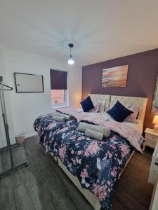 a bedroom with a large bed with a floral bedspread at Sutton Apartment, Greater London in Sutton