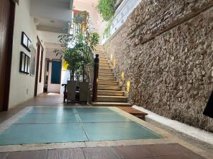 a hallway with stairs and a stone wall at Casa Ebano 967 in Cartagena de Indias