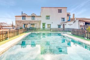 a villa with a swimming pool in front of a house at Luxe Mediterranean Masia BBQ Pool Chillout in Mas de Catalá