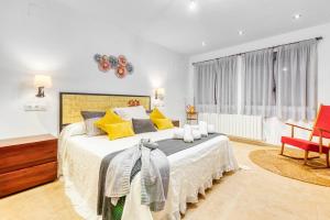 1 dormitorio con 1 cama grande con almohadas amarillas en Luxe Mediterranean Masia BBQ Pool Chillout 