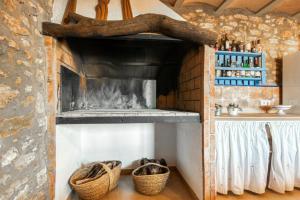 a kitchen with two baskets and a fireplace at Luxe Mediterranean Masia BBQ Pool Chillout in Mas de Catalá +67 photos