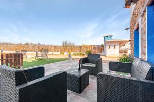 a patio with chairs and a table with a bottle of wine at Luxe Mediterranean Masia BBQ Pool Chillout in Mas de Catalá