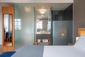 a bedroom with a bed and a bathroom at Santa Catarina FLH Suites in Porto