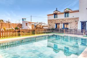 a swimming pool in front of a house with a fence at Luxe Mediterranean Masia BBQ Pool Chillout in Mas de Catalá